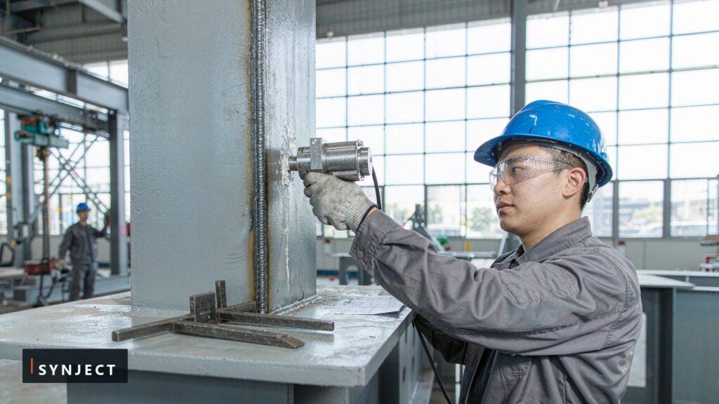 SynJect welding inspector performing ultrasonic testing on a butt weld of a steel box column
