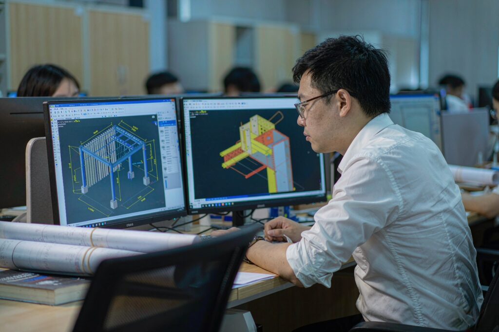 Detailing engineer reviewing a steel structure BIM model and a bolted connection node before fabrication
