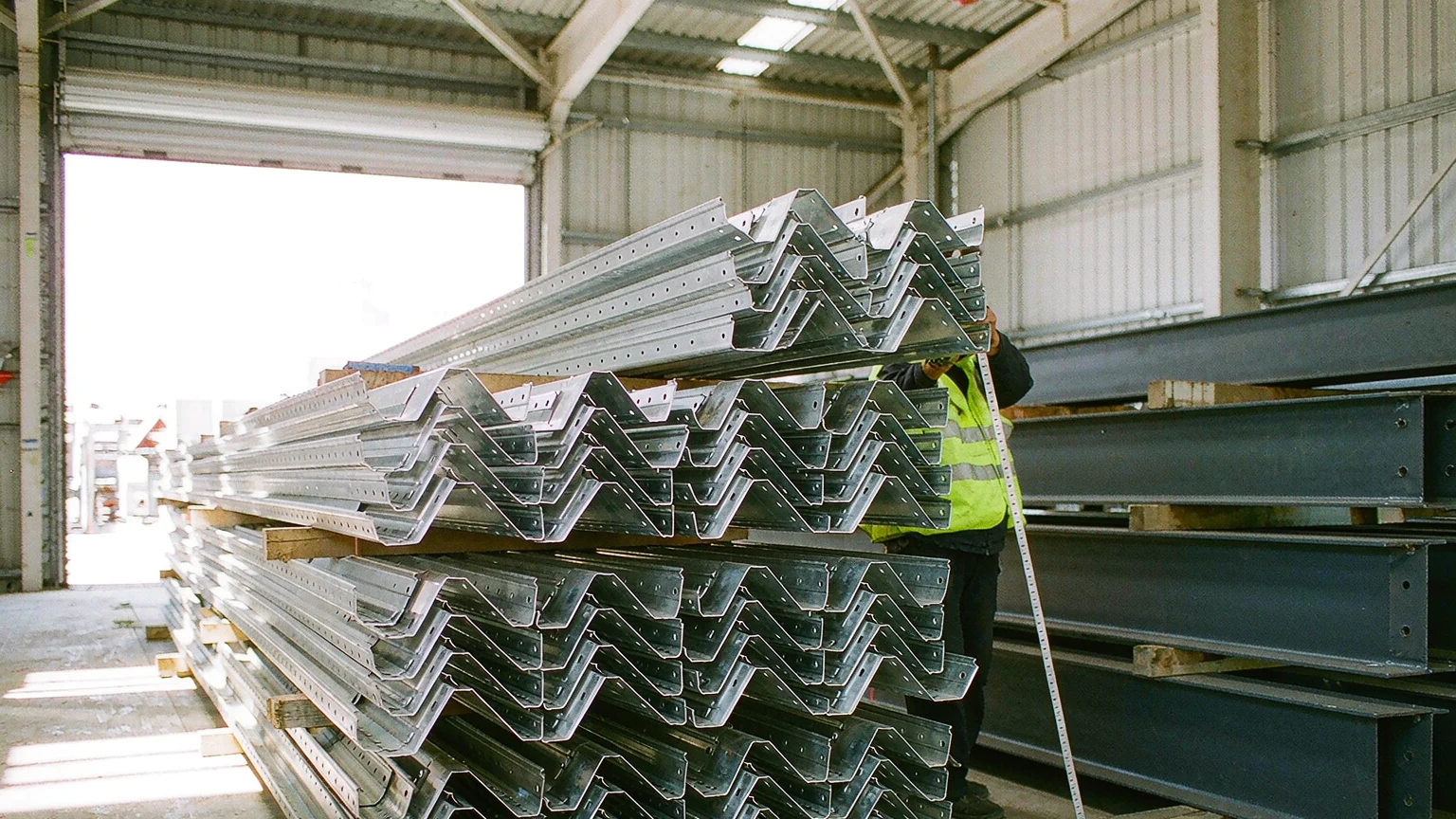 Hot-dip galvanized C and Z steel purlins and coated steel beams stacked on timber dunnage for export packing